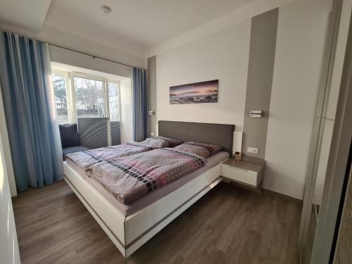 1 dormitorio con 1 cama en una habitación con ventana en FeWo Am Meer Prora, en Binz