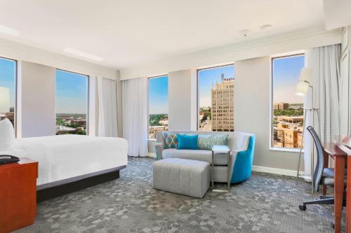 una camera d'albergo con letto, divano e finestre di Courtyard by Marriott Amarillo Downtown ad Amarillo