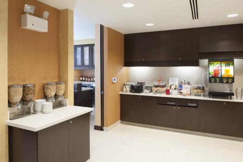 a large kitchen with brown cabinets and a counter at Residence Inn by Marriott Grand Rapids Airport in Grand Rapids