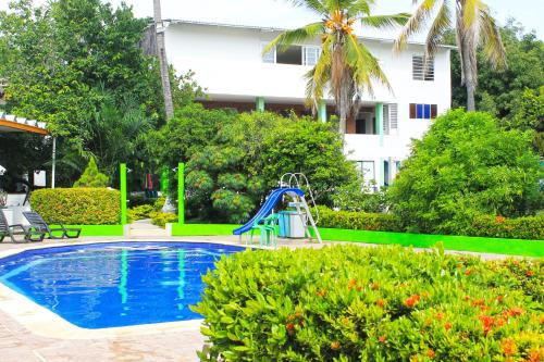 une piscine avec toboggan à côté d'un bâtiment dans l'établissement Casa de Campo Peñalisa Hotel campestre, à Ricaurte