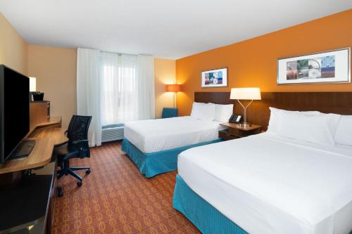 a hotel room with two beds and a flat screen tv at Fairfield Inn and Suites by Marriott Nashville Smyrna in Smyrna