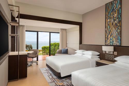 a hotel room with two beds and a desk at Goa Marriott Resort & Spa in Panaji