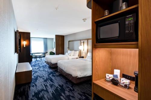 a hotel room with two beds and a flat screen tv at Fairfield Inn & Suites by Marriott Plymouth in Plymouth