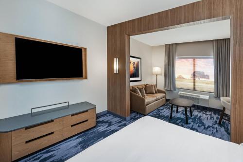 a hotel room with a bed and a flat screen tv at Fairfield Inn & Suites Houston Memorial City Area in Houston