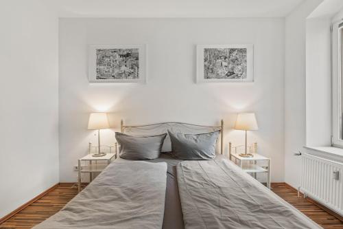 a bedroom with a large bed with two lamps at Budget Apartment am Fernsehturm in Berlin