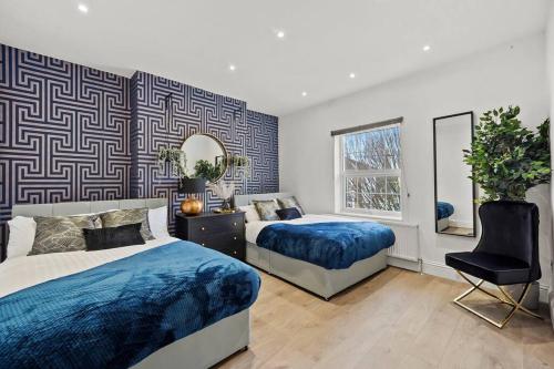 a bedroom with two beds and a mirror at Platinum Grove Modern Flat in Kent