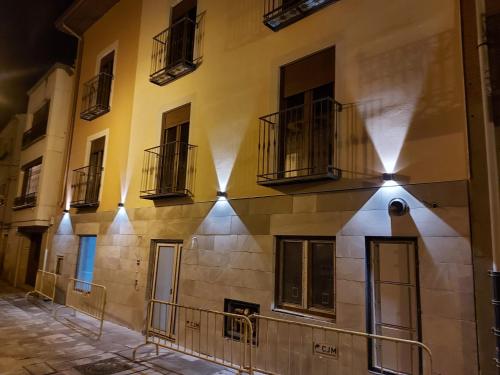 um edifício com janelas e varandas numa rua em Hotel - Hostel Atuvera em Santo Domingo de la Calzada