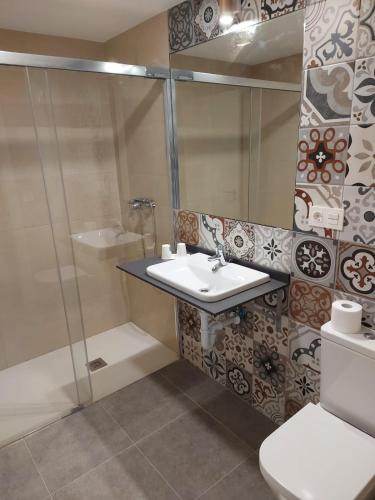 a bathroom with a sink and a shower and a toilet at Hotel - Hostel Atuvera in Santo Domingo de la Calzada