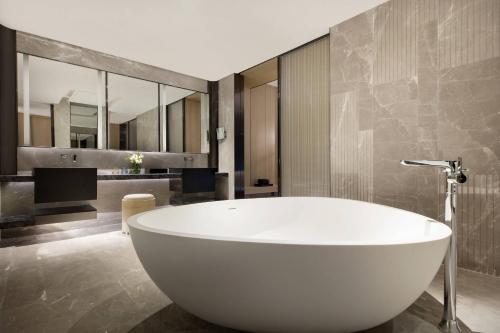 una grande vasca bianca in un bagno con specchi di Courtyard by Marriott Shenzhen Northwest a Bao'an