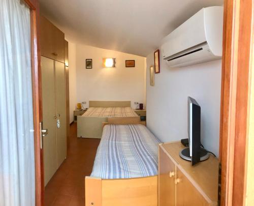 ビビオーネにあるLandoraのベッド1台とテレビが備わる小さな客室です。