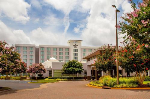 ein großes weißes Gebäude mit Bäumen davor in der Unterkunft Delta Hotels by Marriott Chesapeake Norfolk in Chesapeake