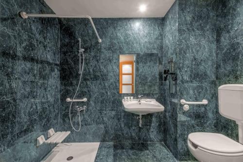 La salle de bains est pourvue de toilettes, d'un lavabo et d'une douche. dans l'établissement AC Hotel Genova by Marriott, à Gênes