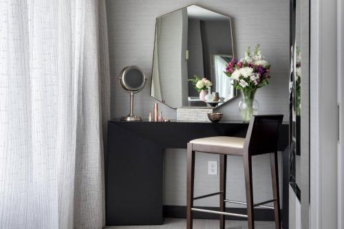 a vanity with a mirror and a stool in a room at Bridgewater Marriott in Bridgewater