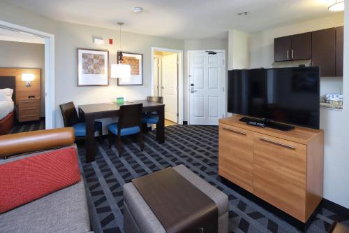a living room with a television and a dining room at TownePlace Suites Tucson in Tucson