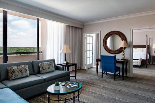 a living room with a couch and a bedroom at Houston Marriott Westchase in Houston