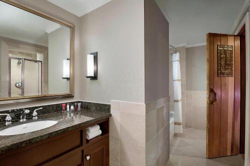 a bathroom with a sink and a mirror and a shower at Houston Marriott Westchase in Houston