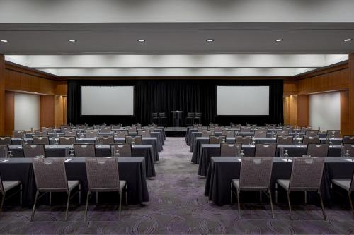 a conference room with tables and chairs and screens at The Opus Westchester, Autograph Collection in White Plains