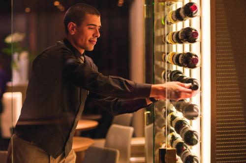 a man standing in front of a wine glass at Mövenpick Hotel & Casino Geneva in Geneva