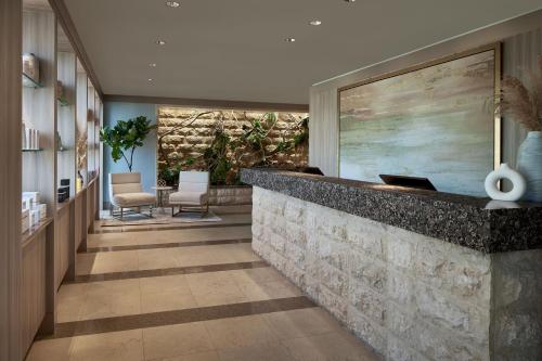 a lobby with a reception counter and chairs at The Opus Westchester, Autograph Collection in White Plains