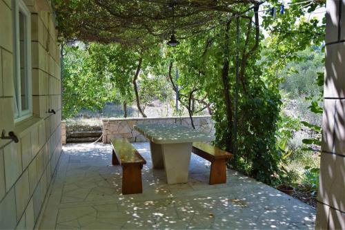 a picnic table and two benches on a patio at Villa Adriana in Selca