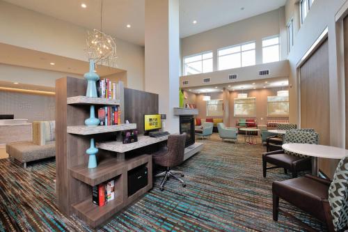 a lobby with a library with a book shelf and chairs at Residence Inn by Marriott Houston Tomball in Tomball