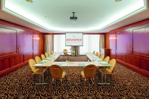 a meeting room with a long table and chairs at Mövenpick Hotel Geneva in Geneva