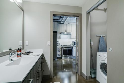 a kitchen with a sink and a washer and dryer at Sable 32 in Minneapolis