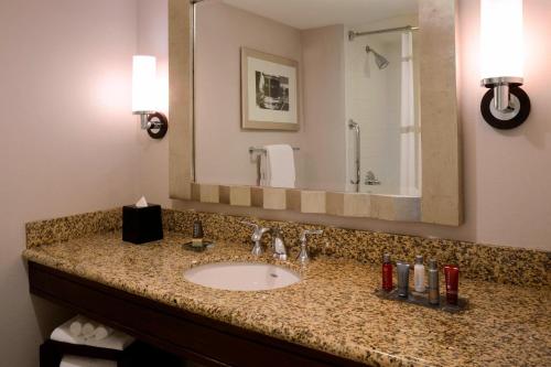 a bathroom with a sink and a large mirror at Newport News Marriott at City Center in Newport News