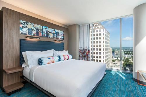 a bedroom with a large bed and a large window at Aloft Austin Downtown in Austin