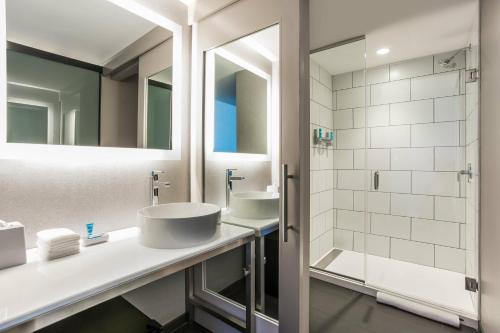 a bathroom with two sinks and a shower at Aloft Austin Downtown in Austin