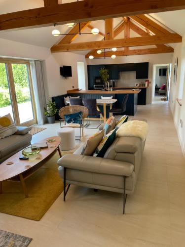 un soggiorno con divano e tavolo di The Stables - Luxury Cottage a Dumfries