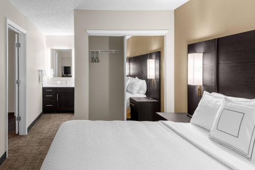 a hotel room with a bed and a bathroom at Residence Inn Atlanta Norcross/Peachtree Corners in Norcross