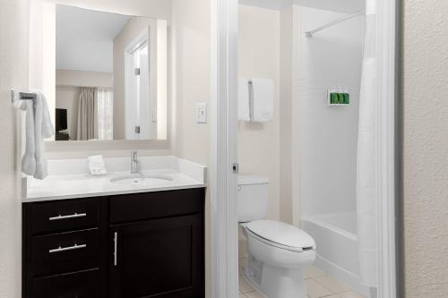 a bathroom with a toilet and a sink and a shower at Residence Inn Atlanta Norcross/Peachtree Corners in Norcross