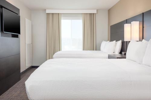 a hotel room with two beds and a flat screen tv at Residence Inn Livermore in Livermore