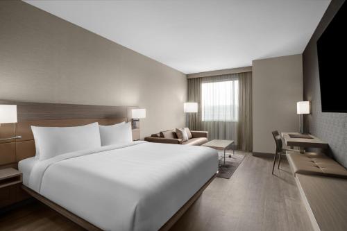 een groot wit bed in een hotelkamer bij AC Hotel by Marriott Pittsburgh Southpointe in Canonsburg