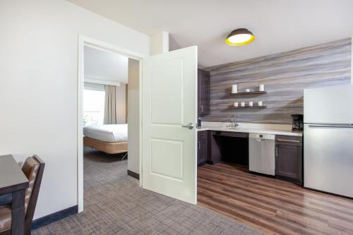 a kitchen with a white refrigerator and a bedroom at Residence Inn Livermore in Livermore