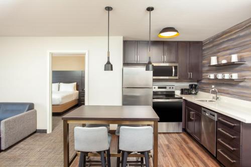 a kitchen with a table and chairs and a bed at Residence Inn Livermore in Livermore