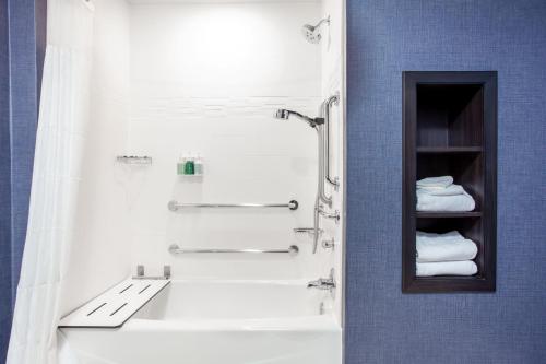 a bathroom with a shower and a sink with towels at Residence Inn Livermore in Livermore