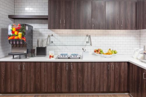 a kitchen with wooden cabinets and a bowl of fruit at Residence Inn Livermore in Livermore