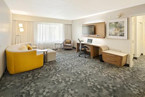 a hotel room with a bed and a desk at Courtyard by Marriott Bryan College Station in College Station