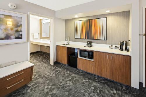 a hotel room with a sink and a bathroom at Courtyard by Marriott Bryan College Station in College Station