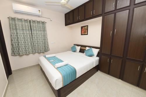 1 dormitorio con 1 cama con armarios marrones en Sree Elite Home Stay, en Tirupati