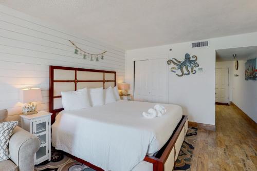 a bedroom with a large white bed and a chair at Islander W 602 in Fort Walton Beach