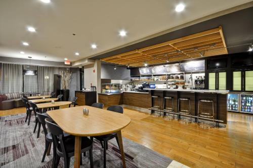 a restaurant with tables and chairs and a bar at Courtyard by Marriott Jacksonville Airport/ Northeast in Jacksonville