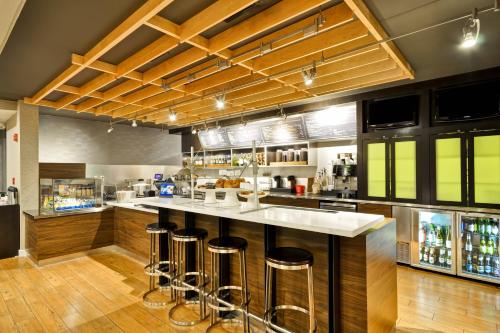 a large kitchen with a bar with stools in it at Courtyard by Marriott Jacksonville Airport/ Northeast in Jacksonville