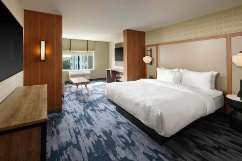 Cette chambre comprend un grand lit et un bureau. dans l'établissement Fairfield Inn & Suites By Marriott Louisville Northeast, à Louisville