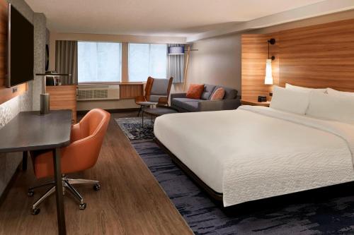 a hotel room with a large bed and a desk at Fairfield Inn by Marriott Montreal Downtown in Montreal