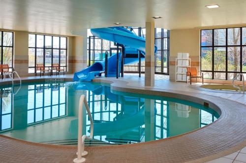 una piscina con un tobogán en un edificio en Courtyard by Marriott Kingston Highway 401 en Kingston