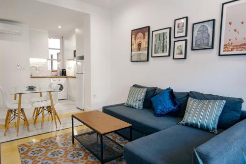 a living room with a blue couch and a table at Granadi Apartamentos in Granada