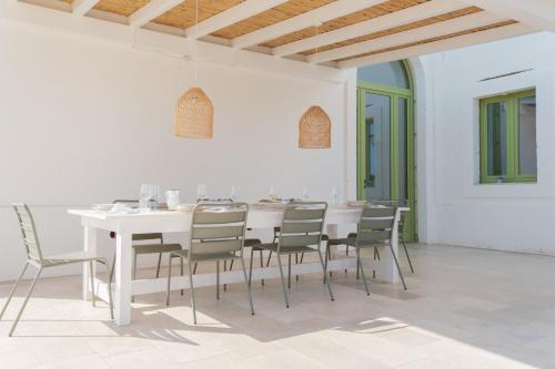 Un comedor blanco con una mesa y sillas blancas. en Masseria Egnazia - Epoca Collection, en Savelletri di Fasano